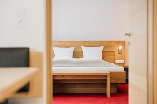 a bedroom with a bed with white sheets and pillows at Pension Gabl in Pfunds