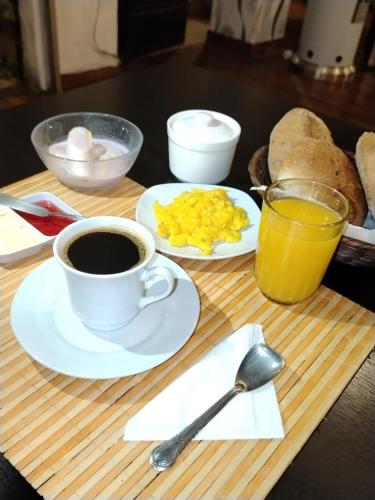 a table with a cup of coffee and a plate of eggs at Hotel Avenida in La Paz