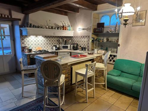 a kitchen with a green couch and a table at la maison d'Emilia verdure et murmure de l'eau 