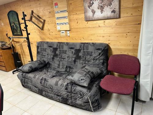 a living room with a couch and a chair at Gîte au bord de la mare in Saint-Romain-de-Colbosc