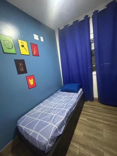 Schlafzimmer mit einem Bett mit blauen Wänden und blauen Vorhängen in der Unterkunft Quarto em Apartamento Vila Prudente in São Paulo