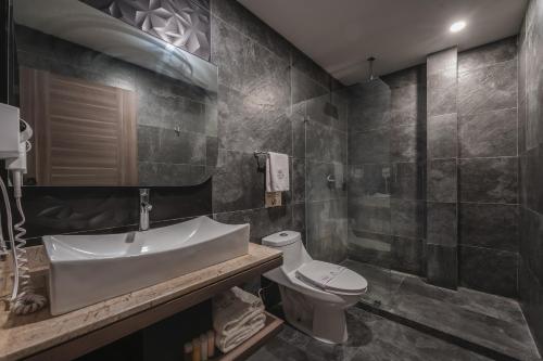 a bathroom with a sink and a toilet at Hotel Kavia Premium - Paseo Montejo in Mérida
