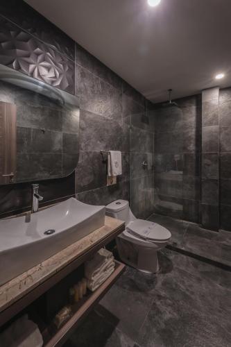 a bathroom with a toilet and a sink at Hotel Kavia Premium - Paseo Montejo in Mérida
