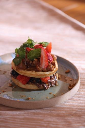 Una pila de panqueques con fresas y verduras en un plato. en Origem Patacho Design Hotel, en Porto de Pedras