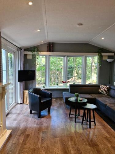 a living room with a couch and a table at Chalet Vakantie Wageningen Veluwe in Wageningen