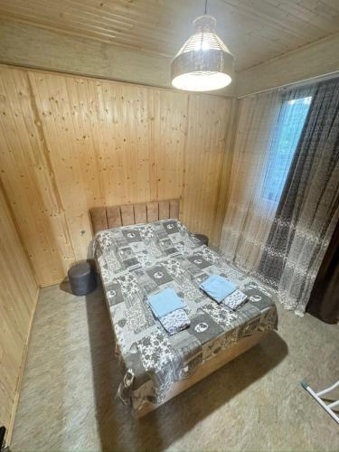 Una habitación con una cama en una habitación de madera. en Villa, en Tsikhisdziri