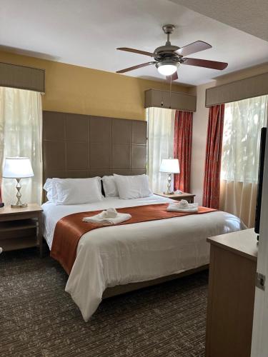 a bedroom with a large bed with a ceiling fan at Central Location to all Parks and Convention center in Orlando