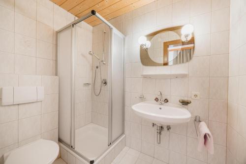 a bathroom with a shower and a sink and a toilet at Pension Gabl in Pfunds