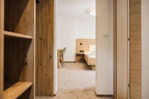 a hallway with a room with a bed and a desk at Pension Gabl in Pfunds