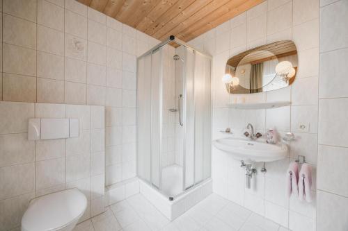 a bathroom with a shower and a toilet and a sink at Pension Gabl in Pfunds