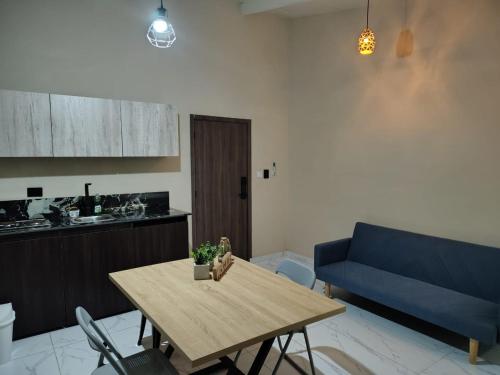 a living room with a table and a blue couch at Laureles del parque loft in Barranquilla