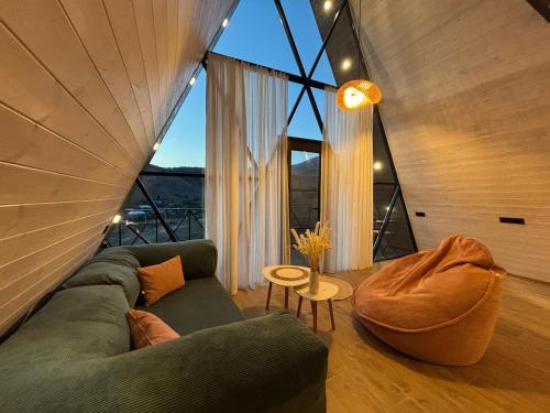a living room with a couch and a large window at Space Trip Hotel in Artavaz