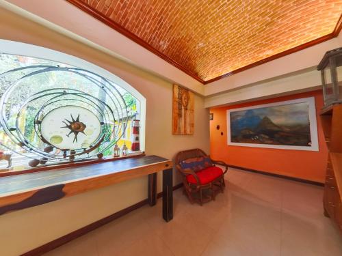 a room with a window with a clock and a chair at Villa Amable, Lujo entre Selvas y Lagunas in Akumal