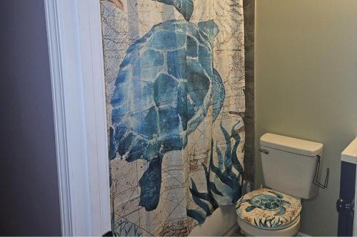a bathroom with a dolphin shower curtain with a toilet at The Village in Atlanta