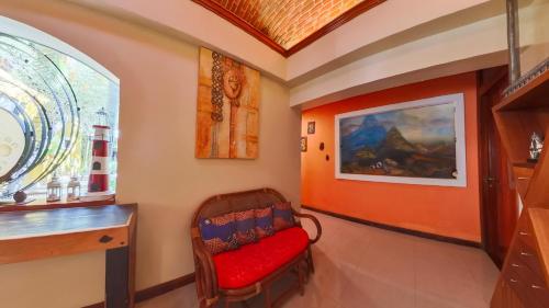 a room with a red chair and a window at Villa Amable, Lujo entre Selvas y Lagunas in Akumal