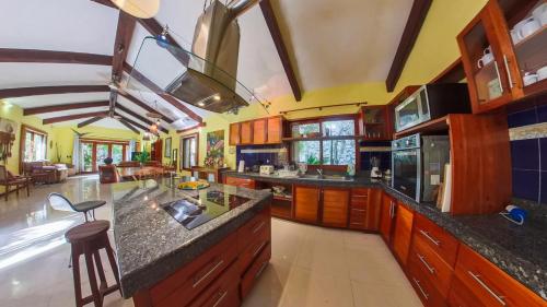 a large kitchen with wooden cabinets and counters at Villa Amable, Lujo entre Selvas y Lagunas in Akumal