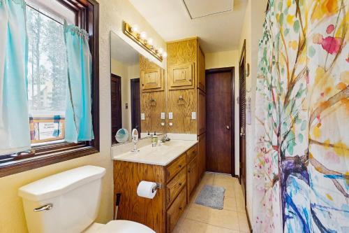 a bathroom with a white toilet and a sink at Pine Valley Lodge in Angel Fire