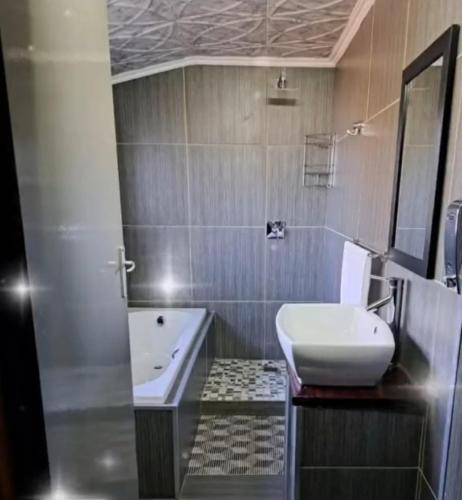 a bathroom with a sink and a toilet and a tub at Indabuch in Rustenburg