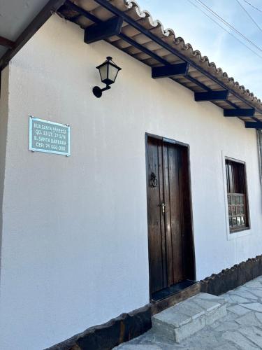 a white building with a door and a sign on it at Pousada Canta Galo in Goiás