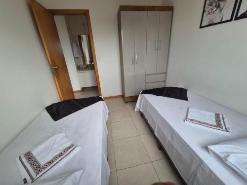 two beds in a small room with a door at 301 Lugar de Veraneio in Serra