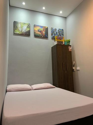 ein Bett in einem Zimmer mit drei Gemälden an der Wand in der Unterkunft Flat MDC 02 in Iturama