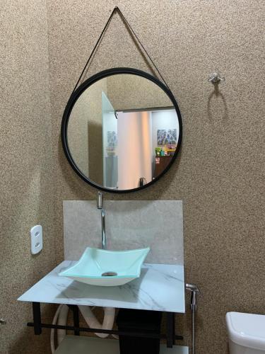 ein Spiegel über einem Waschbecken im Badezimmer in der Unterkunft Flat MDC 02 in Iturama