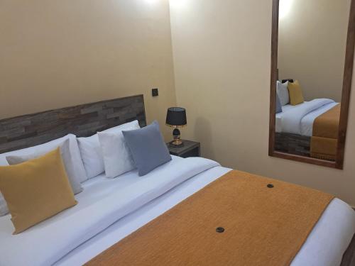 a bedroom with a large bed with a mirror at Nice & Slow Homes in Arusha