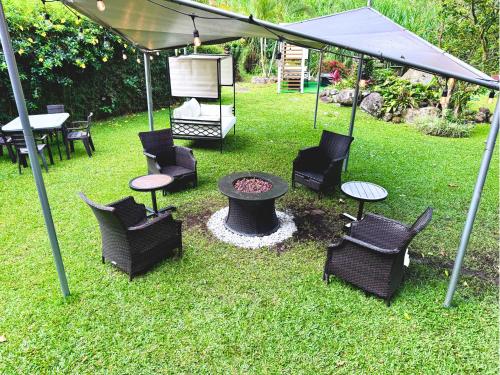 a group of chairs and a fire pit under a tent at Hotel Valle del Rio in Boquete