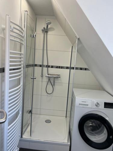 a bathroom with a shower and a washing machine at Ferienwohnung am Uniklinik Lübeck in Lübeck