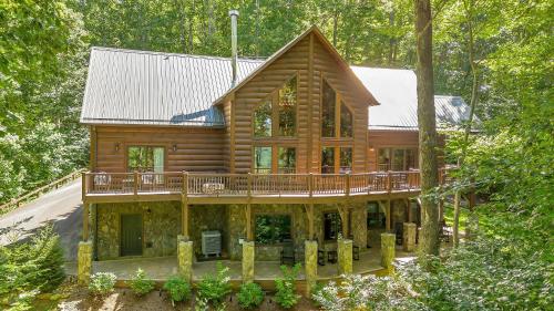 a log cabin with a deck in the woods at Our Place to Paws 4 Bd Lux Blue Ridge Mnt Cabin in Lansing