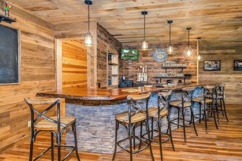 a bar in a restaurant with wooden walls and stools at Our Place to Paws 4 Bd Lux Blue Ridge Mnt Cabin in Lansing