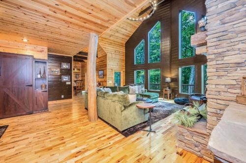 a living room with a couch and a stone wall at Our Place to Paws 4 Bd Lux Blue Ridge Mnt Cabin in Lansing