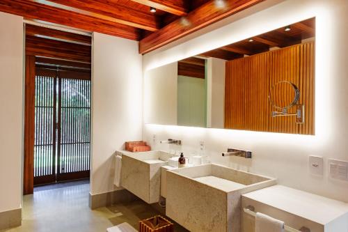 a bathroom with two sinks and a large mirror at Zendaya Resort Beach Sport & Spa in Búzios