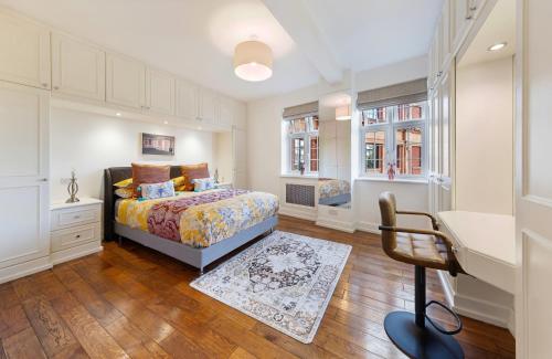 a bedroom with a bed and a desk and a chair at ROYAL Apartment in HARRODS in London