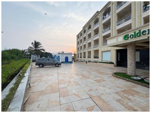 a car parked in front of a building at Private Beach Hotel Golden Palace with Swimming Pool in Puri in Puri