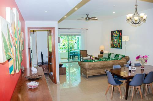 a living room with a couch and a table and chairs at Palmar del Sol by Riviera Maya Suites in Playa del Carmen