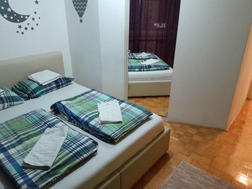 two beds in a room with a mirror at Apartman centar lux in Tuzla