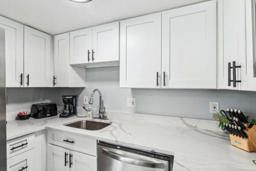 a white kitchen with a sink and white cabinets at All New! Convenient Location! Sleeps 6 in Denver