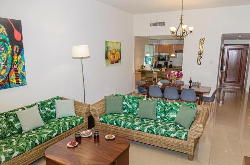 a living room with two couches and a table at Palmar del Sol by Riviera Maya Suites in Playa del Carmen