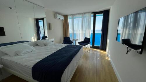 a bedroom with a bed and a view of the ocean at Orbi City Superhost in Batumi