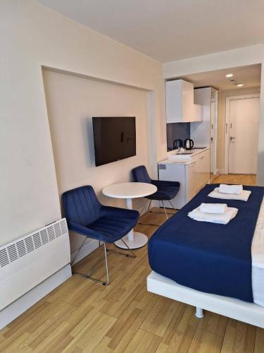 a bedroom with a blue bed and a table and chairs at Orbi City Superhost in Batumi