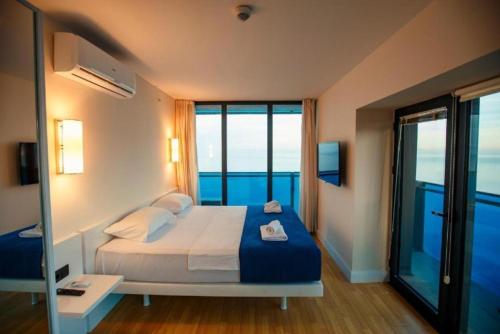 a bedroom with a bed with a view of the ocean at Orbi City Superhost in Batumi