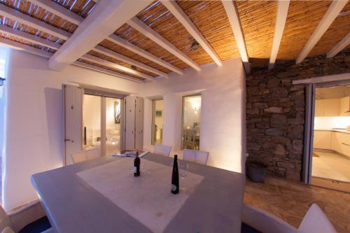 a dining room with a table and a stone wall at Villa Lia in Kalafatis