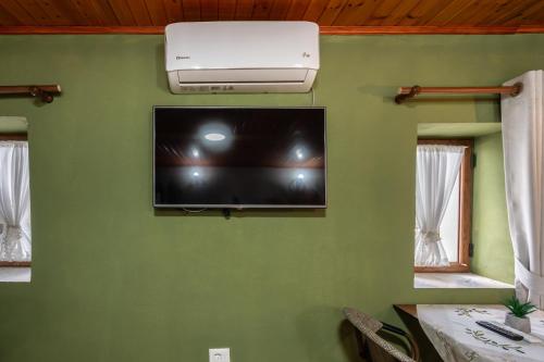 a flat screen tv on a green wall at Keshtjella Xhabeqos in Tirana