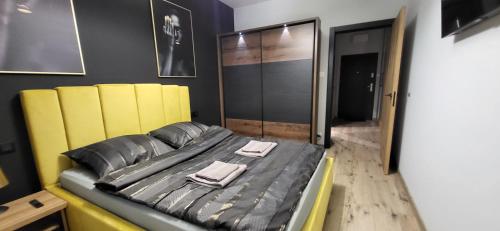 a bedroom with a bed with two towels on it at Apartament Number One in Płock