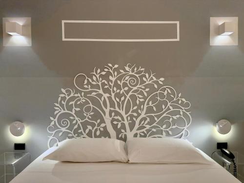 a bedroom with a bed with a tree mural on the wall at Hotel Europa Varese in Varese