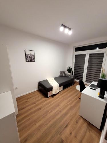 a bedroom with a bed and a desk in it at Pobitno cosy rooms in Rzeszów