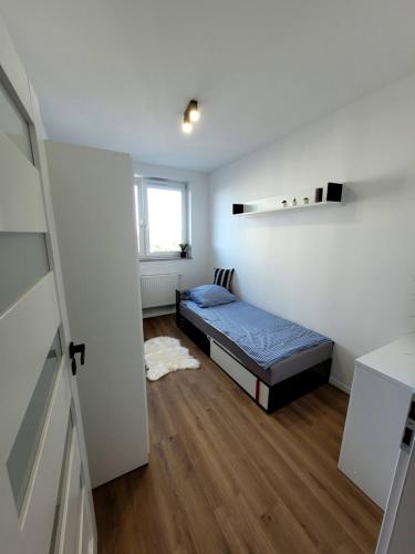 a small bedroom with a bed and a window at Pobitno cosy rooms in Rzeszów