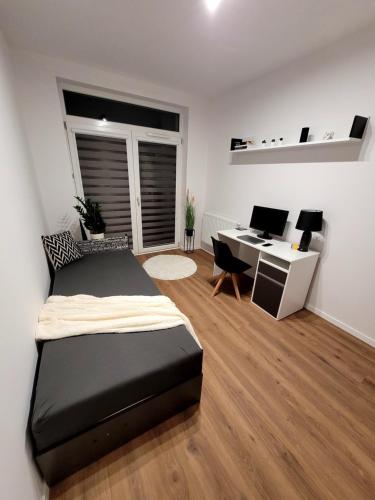 a bedroom with a bed and a desk at Pobitno cosy rooms in Rzeszów