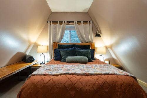 una camera da letto con un letto grande con una finestra di Secluded Forest Cabin with Hot Tub and Private Waterfall a Rockport